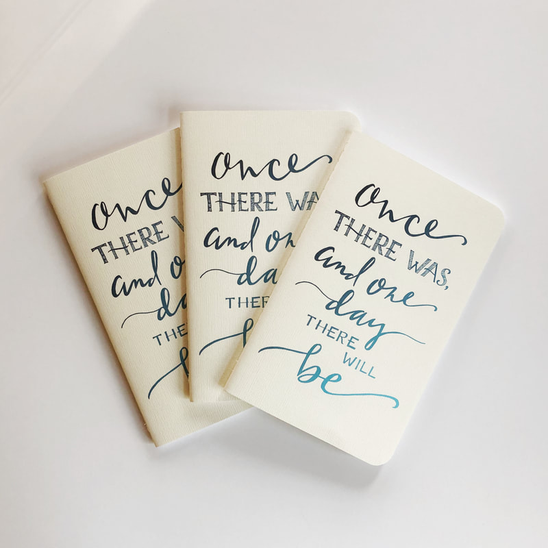 photo of three cream-colored notebooks handlettered with the quote, 