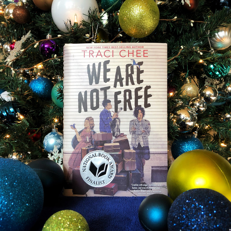 the book We Are Not Free by Traci Chee surrounded by green and blue ornaments
