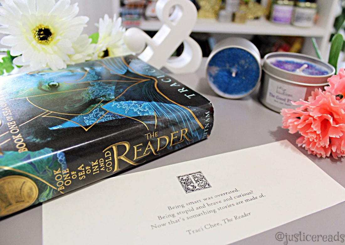 The Reader book is surrounded by candles and flowers