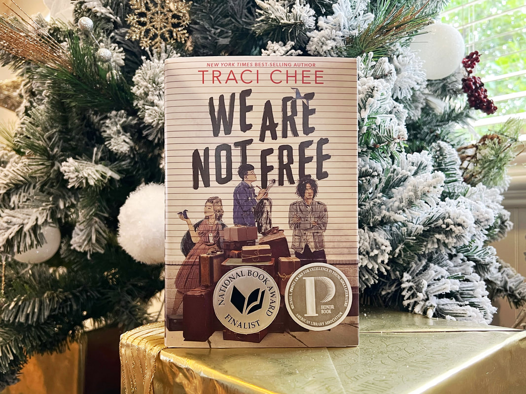 hardcover of We Are Not Free in front of a snowy Christmas tree