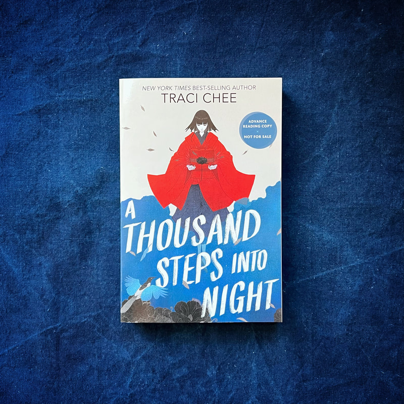 ARC of A Thousand Steps into Night by Traci Chee on a blue cloth field