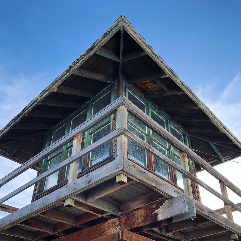 A view of a wooden guard tower from below against a vivid blue sky