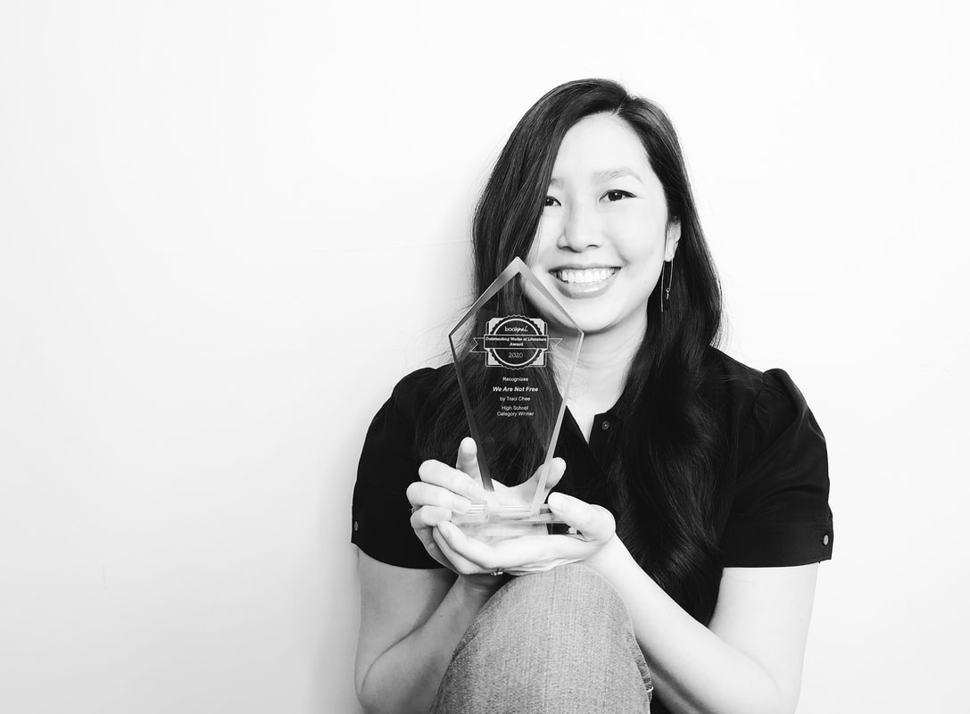 black and white photo of Traci Chee holding up a diamond-shaped crystal award