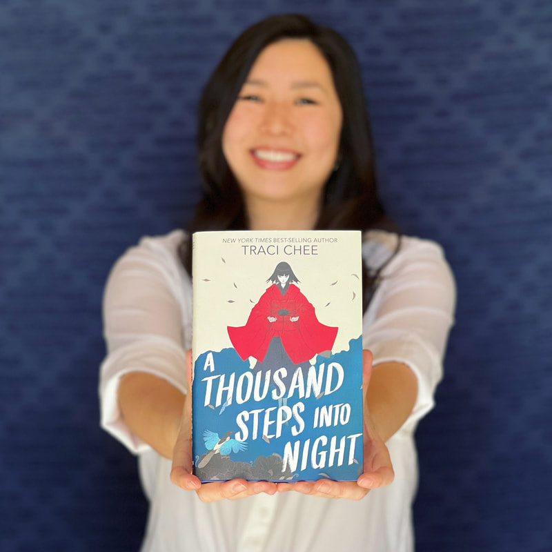 Traci Chee, out of focus, holding up in focus a hardcover of A THOUSAND STEPS INTO NIGHT, with a blue background