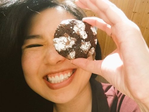 photo of Traci Chee holding a powdery chocolate cookie up to her eye